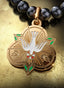The Advocate Medallion with gold connector on a pearl necklace, elegantly displayed on a table.