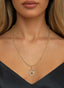 The Revelation Medallion in 14K gold, worn on a necklace, symbolizing faith, renewal, and hope.