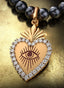 The Revelation Medallion with gold connector on a pearl necklace, elegantly displayed on a table.