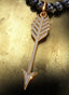 Secret Weapon Medallion (Large) with gold connector on a pearl necklace, displayed on a table.