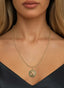 Roots & Branches Medallion in 14K gold, worn on a necklace, symbolizing unity and divine grace.