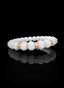 Side view of Abundant Seed Bracelet with white opal and gold.