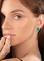 Model wearing emerald and diamond earrings, highlighting their elegance, size, and glamorous design.