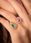 Close-up of emerald, pink sapphire, and diamond ring, showcasing fine details.