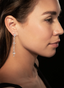 Side view of model wearing diamond long dangle earrings, highlighting how they hang on the ear.