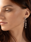 Model wearing diamond double dangle earrings, highlighting their size, movement, and luxury appeal.