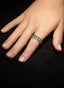 Model wearing emerald and diamond eternity band, highlighting its size and elegance.