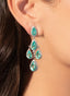 Model wearing emerald and diamond earrings in 18K white gold, showcasing their special design.