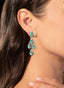 Model wearing emerald and diamond earrings, highlighting their elegance, size, and luxurious design.