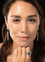 Model wearing 14.48 carat emerald and diamond earrings, highlighting their size and elegant design.