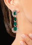 Close up of emerald and diamond earrings in 18K white gold, showcasing their brilliance.