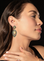 Model wearing emerald, opal, and diamond earrings, highlighting size, proportion, and unique design.