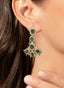 Model wearing 9.45 carat emerald and diamond earrings in 18K yellow gold, showcasing their design.