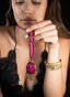Model holding ruby and white sapphire necklace, displaying size, proportion, and elegance.