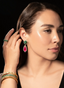 Model wearing emerald, pink tourmaline, and diamond drop earrings, displaying size and elegance.