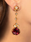 Close-up of rhodolite and diamond drop earrings, showcasing intricate craftsmanship.