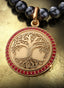 Roots & Branches Medallion with gold connector on a pearl necklace, elegantly displayed on a table.