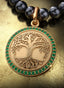 Roots & Branches Medallion with gold connector on a pearl necklace, elegantly displayed on a table.