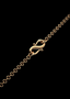 Detail of the back clasp on 18" INSPOCCO gold link chain, on black background.