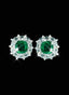 Emerald and diamond earrings in 18K white gold against black background, showcasing gemstone beauty.
