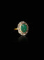 Close-up of emerald and rose-cut diamond ring on black background, highlighting gemstone brilliance.